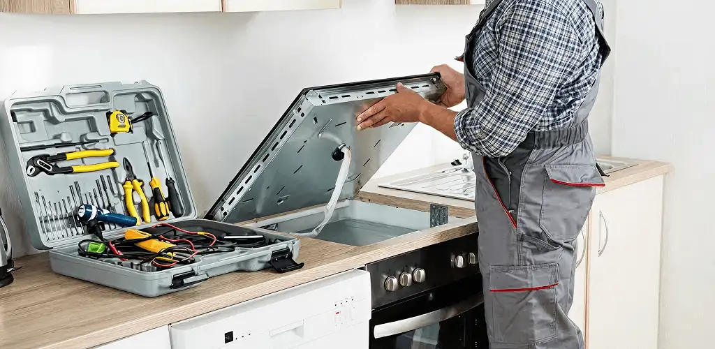 Handyman repairing a cooktop and checking wiring connections in Grand Rapids, MI