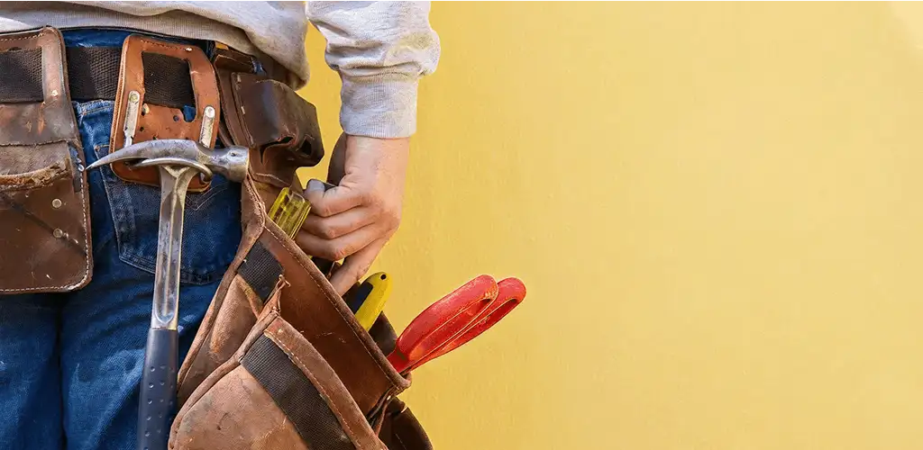 Handyman with tool belt ready for home repairs and maintenance in Grand Rapids, MI