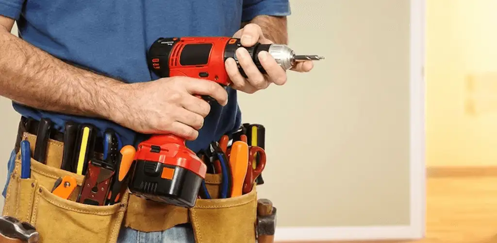 Handyman holding a power drill for home repairs and installations in Grand Rapids, MI