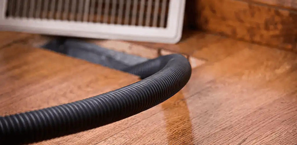 Air duct cleaning hose inserted into a floor vent for ductwork cleaning in Grand Rapids, MI
