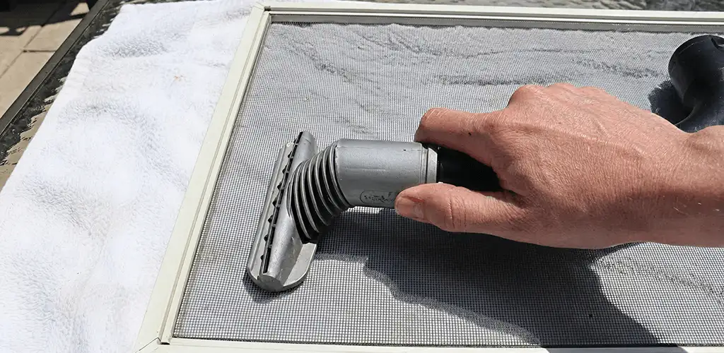 Window screen repair cleaning and fixing a damaged screen mesh in Grand Rapids, MI